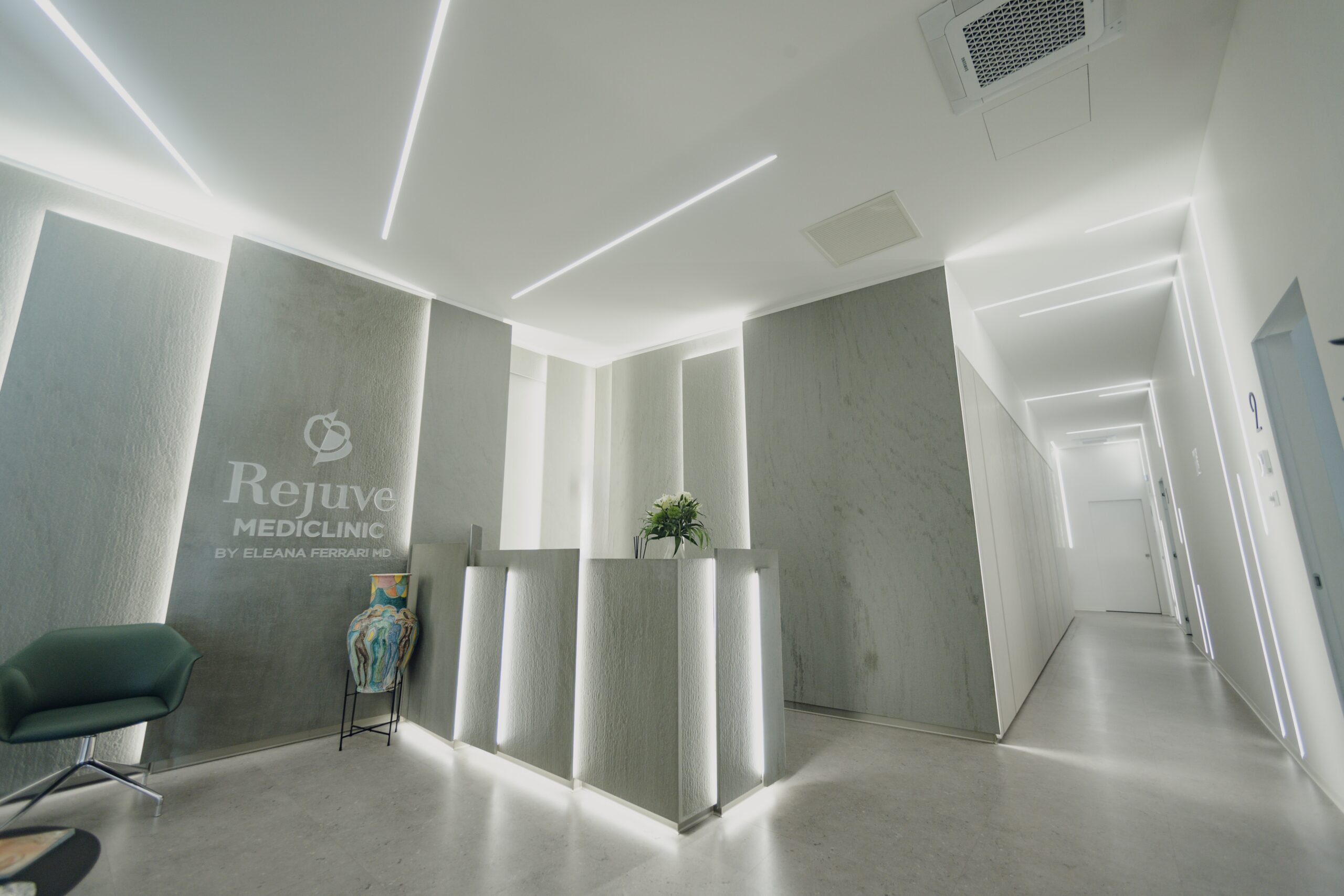 Modern and stylish reception area at Rejuve MediClinic, featuring minimalist design, ambient lighting, and the clinic's logo on the wall.