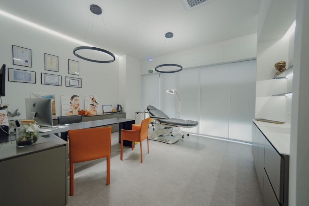 Studio medico di Rejuve MediClinic, con arredi moderni, pareti chiare, poltrona per trattamenti estetici e certificazioni esposte alle pareti.